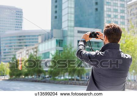 Picture - Young attractive man photographing the beautiful views in the city. Fotosearch