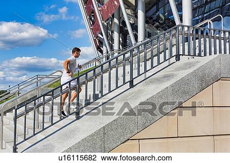 Stock Image - Young attractive man running in stairs. Fotosearch