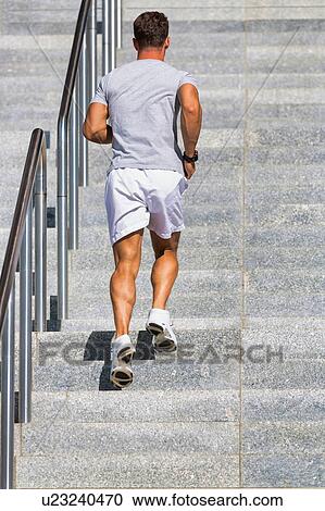 Stock Image - Young attractive man running in stairs. Fotosearch