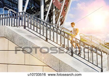 Stock Photograph - Young attractive man running in stairs. Fotosearch