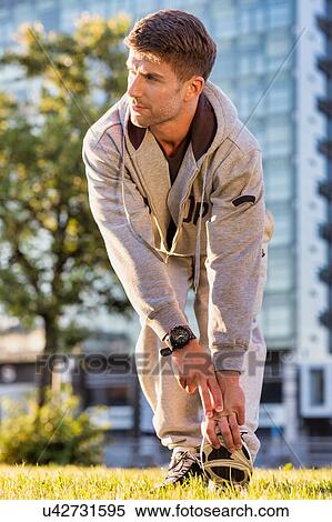 Stock Photography - Young attractive man stretching in park. Fotosearch