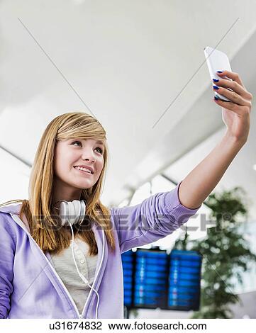 Young attractive teenage girl taking selfie in airport View Large Photo Image Stock Image - Young attractive teenage girl taking selfie in airport. Fotosearch