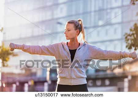 Young attractive woman exercising and holding dumbell View Large Photo Image Stock Photo - Young attractive woman exercising and holding dumbell . Fotosearch