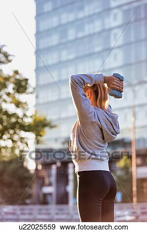 Young attractive woman exercising and holding dumbell View Large Photo Image Stock Photo - Young attractive woman exercising and holding dumbell . Fotosearch