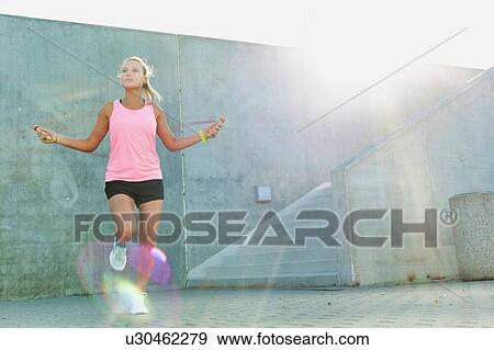 Young attractive woman exercising by jumping on rope  View Large Photo Image Stock Photo - Young attractive woman exercising by jumping on rope . Fotosearch