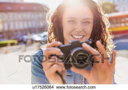 Young attractive woman holding camera and taking photo View Large Photo Image Picture - Young attractive woman holding camera and taking photo . Fotosearch