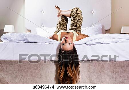 Picture - Young attractive woman lying on bed . Fotosearch