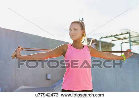 Young attractive woman stretching her arms with rope View Large Photo Image Stock Image - Young attractive woman stretching her arms with rope . Fotosearch