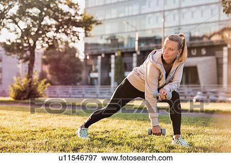 Young attractive woman stretching in park View Large Photo Image Stock Photo - Young attractive woman stretching in park. Fotosearch