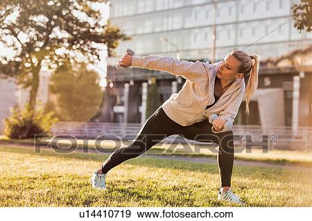 Young attractive woman stretching in park View Large Photo Image Stock Photo - Young attractive woman stretching in park. Fotosearch