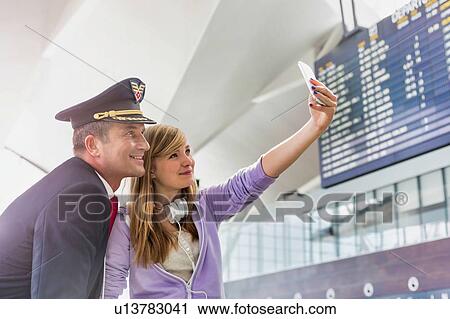 Young beautiful teenage girl taking selfie with mature pilot in airport View Large Photo Image Stock Image - Young beautiful teenage girl taking selfie with mature pilot in airport. Fotosearch