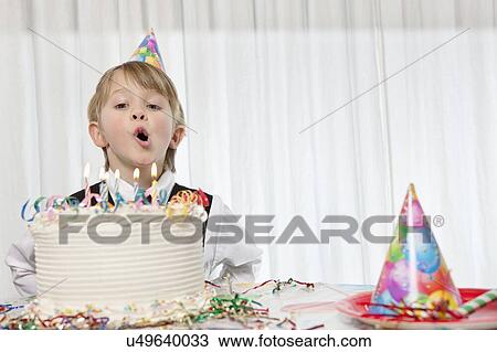 Young birthday boy blowing candles on cake View Large Photo Image Stock Image - Young birthday boy blowing candles on cake. Fotosearch