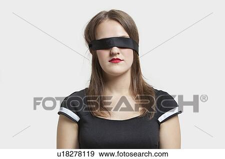 Young blindfolded woman against gray background View Large Photo Image Stock Photo - Young blindfolded woman against gray background. Fotosearch