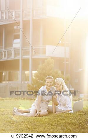 Young businesswomen gossiping in office lawn View Large Photo Image Stock Image - Young businesswomen gossiping in office lawn. Fotosearch