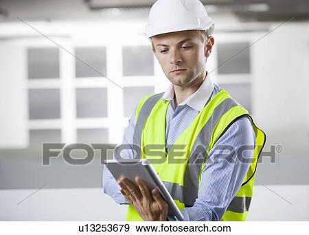 Young Caucasian architect using digital tablet at office View Large Photo Image Stock Photo - Young Caucasian architect using digital tablet at office. Fotosearch