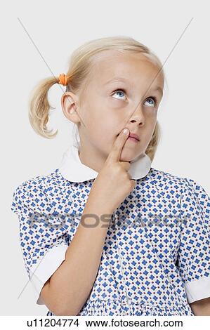 Picture - Young Caucasian girl thinking with finger on lips over white background. Fotosearch