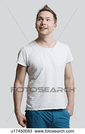 Young Caucasian man in casuals looking away against white background View Large Photo Image Stock Image - Young Caucasian man in casuals looking away against white background. Fotosearch