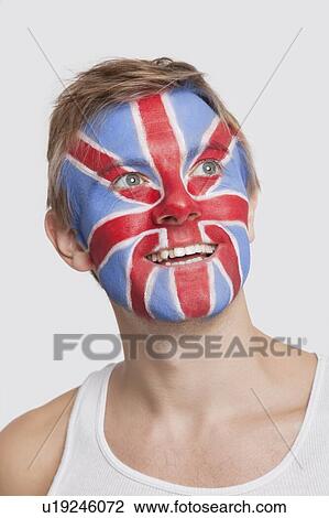 Young Caucasian man with British flag painted on face day dreaming against white background View Large Photo Image Stock Image - Young Caucasian man with British flag painted on face day dreaming against white background. Fotosearch