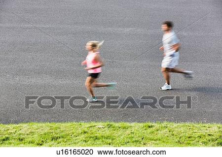 Stock Image - Young couple excersising in park. Fotosearch