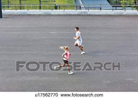 Stock Image - Young couple excersising in park. Fotosearch