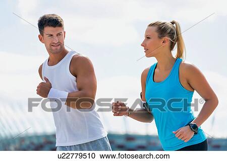 Young couple excersising in park View Large Photo Image Stock Image - Young couple excersising in park. Fotosearch