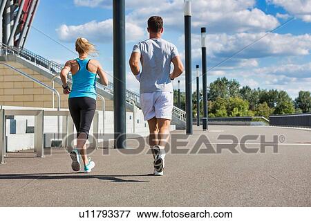 Young couple excersising in park View Large Photo Image Stock Photo - Young couple excersising in park. Fotosearch