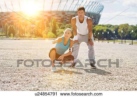 Young couple excersising in the middle of the city View Large Photo Image Stock Image - Young couple excersising in the middle of the city. Fotosearch