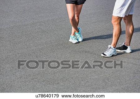 Young couple standing while talking after exercising View Large Photo Image Stock Photo - Young couple standing while talking after exercising. Fotosearch