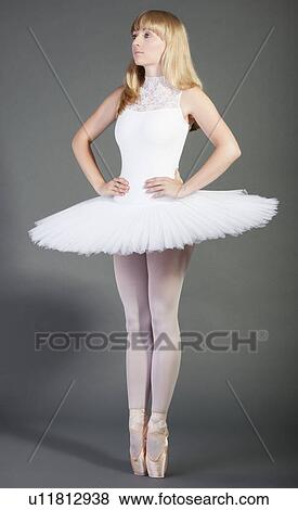 Stock Photo - Young female ballet dancer in wearing tutu tiptoeing over grey background. Fotosearch