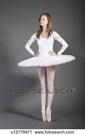 Young female ballet dancer tiptoeing against grey background View Large Photo Image Stock Image - Young female ballet dancer tiptoeing against grey background. Fotosearch