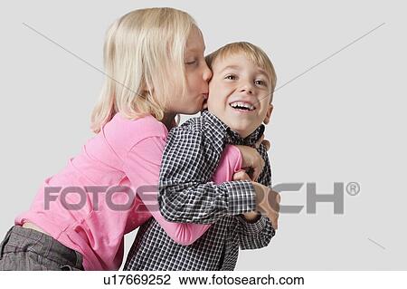 Young girl kissing and embracing brother over white background View Large Photo Image Stock Image - Young girl kissing and embracing brother over white background. Fotosearch