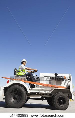 Young male ground crew driving truck at airport runway View Large Photo Image Stock Image - Young male ground crew driving truck at airport runway. Fotosearch