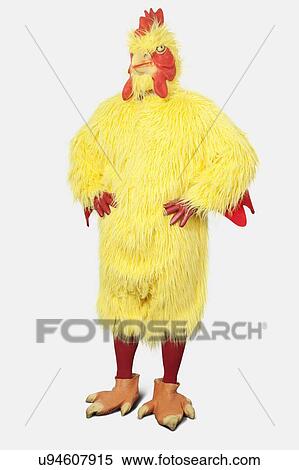 Young man in chicken suit standing with hands on hips against gray background View Large Photo Image Stock Photography - Young man in chicken suit standing with hands on hips against gray background. Fotosearch