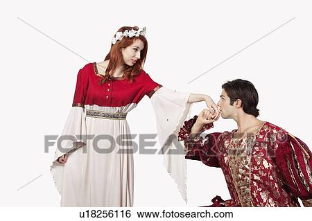 Young man in old-fashioned costume kissing princess's hand against gray background View Large Photo Image Stock Photograph - Young man in old-fashioned costume kissing princess's hand against gray background. Fotosearch