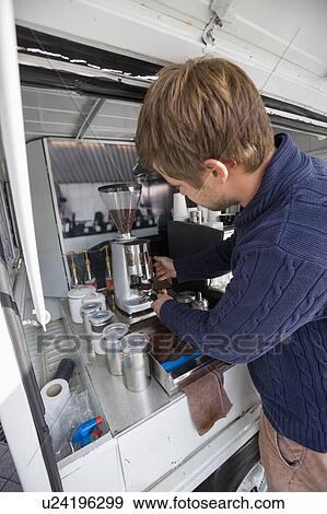 Stock Photo - Young man preparing coffee in mobile coffee shop. Fotosearch