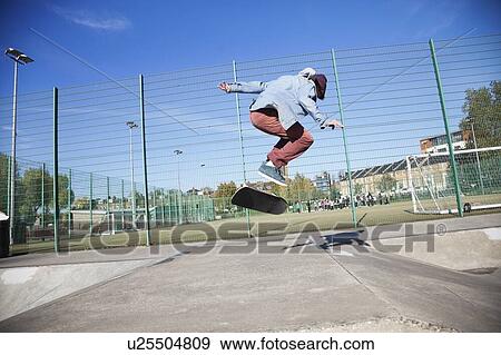 Stock Photo - Young man skateboarding and doing Ollie. Fotosearch