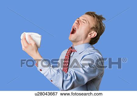 Young man sneezing with open mouth and handkerchief View Large Photo Image Stock Photo - Young man sneezing with open mouth and handkerchief. Fotosearch