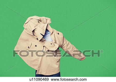 Stock Photo - Young man wearing jacket while looking from jacket over green background. Fotosearch