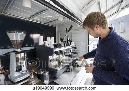 Stock Photo - Young man working at mobile coffee shop. Fotosearch