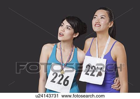 Stock Image - Young medalists looking up against black background. Fotosearch