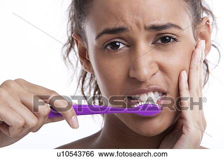 Young Mixed Race woman with toothbrush suffering from toothache against white background View Large Photo Image Stock Photograph - Young Mixed Race woman with toothbrush suffering from toothache against white background. Fotosearch