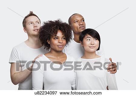 Stock Photo - Young multi-ethnic friends in white t-shirts looking away over white background. Fotosearch