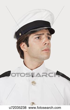 Stock Photo - Young navy officer looking away against gray background. Fotosearch