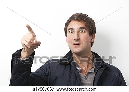 Young shocked man gesturing against white background View Large Photo Image Stock Photo - Young shocked man gesturing against white background. Fotosearch