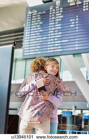 Young teenage girl reuniting with her mother in airport View Large Photo Image Stock Image - Young teenage girl reuniting with her mother in airport. Fotosearch