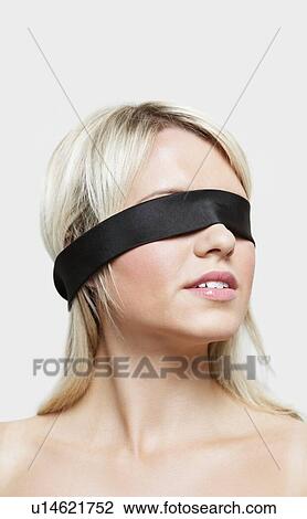 Stock Image - Young woman blindfolded over gray background. Fotosearch