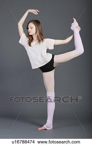 Picture - Young woman performing ballet over grey background. Fotosearch
