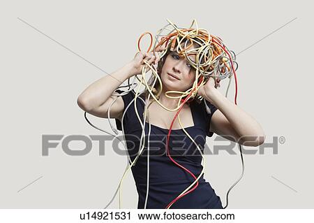Young woman with head tangled in colorful cables over gray background View Large Photo Image Stock Image - Young woman with head tangled in colorful cables over gray background. Fotosearch