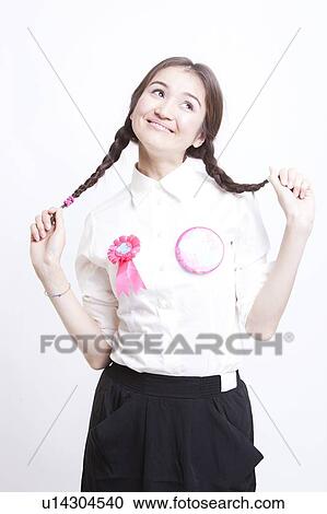 Stock Image - Young woman with pigtails daydreaming against white background. Fotosearch