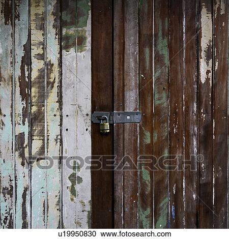 Stock Image - Close-up of a padlocked weathered door, Kuranda, Queensland, Australia. Fotosearch